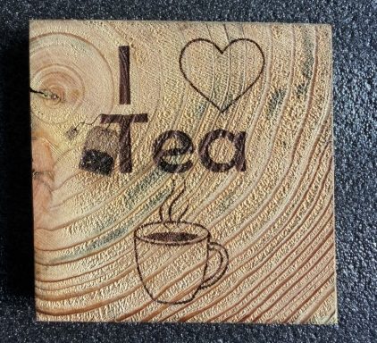 Wooden fence post slice Coaster with "I ❤️ Tea" and a steaming cup illustration.